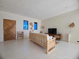 Coin salon TV elegant avec canape moderne en bois et sol clair dans une villa a koh Samui