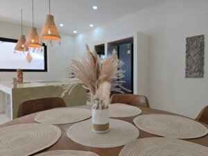 Table a manger en bois avec decoration en pampas et sets de table tresses dans une villa a koh samui