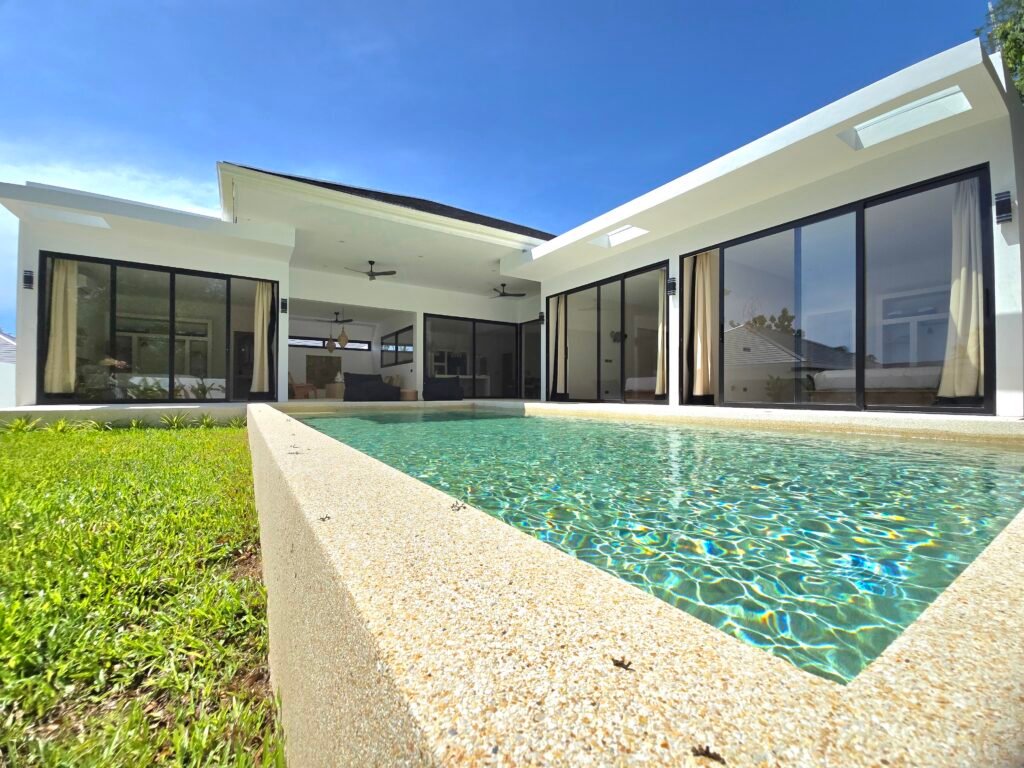 Exterior view of swimming pool and luxury villa with large bay window