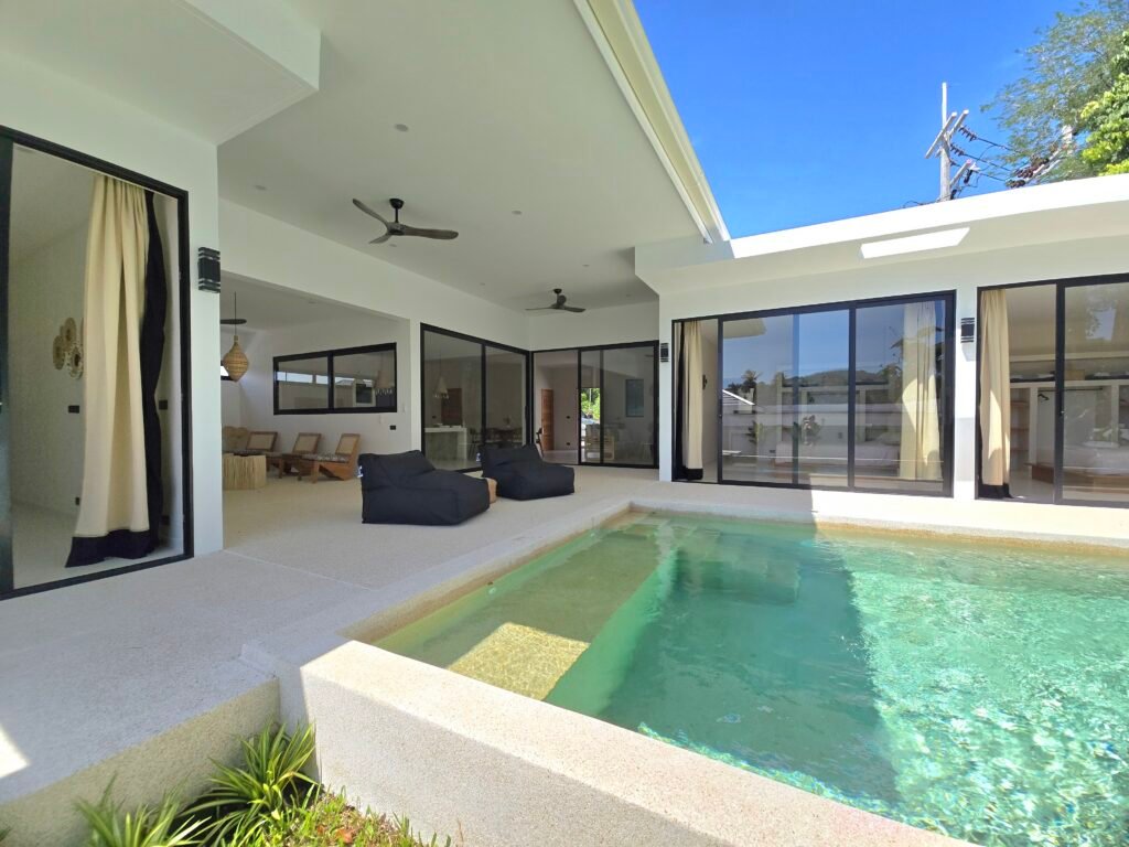 View taken from the garden of a luxury villa with swimming pool and large bay windows