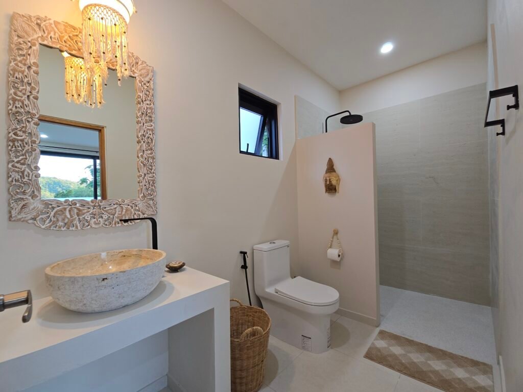 Bathroom with wooden mirror, stone sink and refined decor